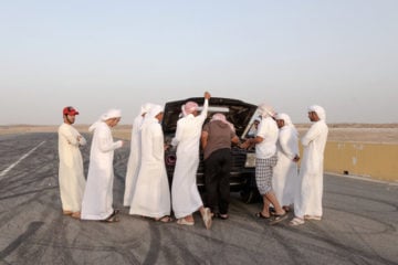 Young men address a mechanical problem.