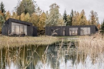 Cute little colorful private real sauna house by the private lake shore in autumn, yellow autumn tree leaves.