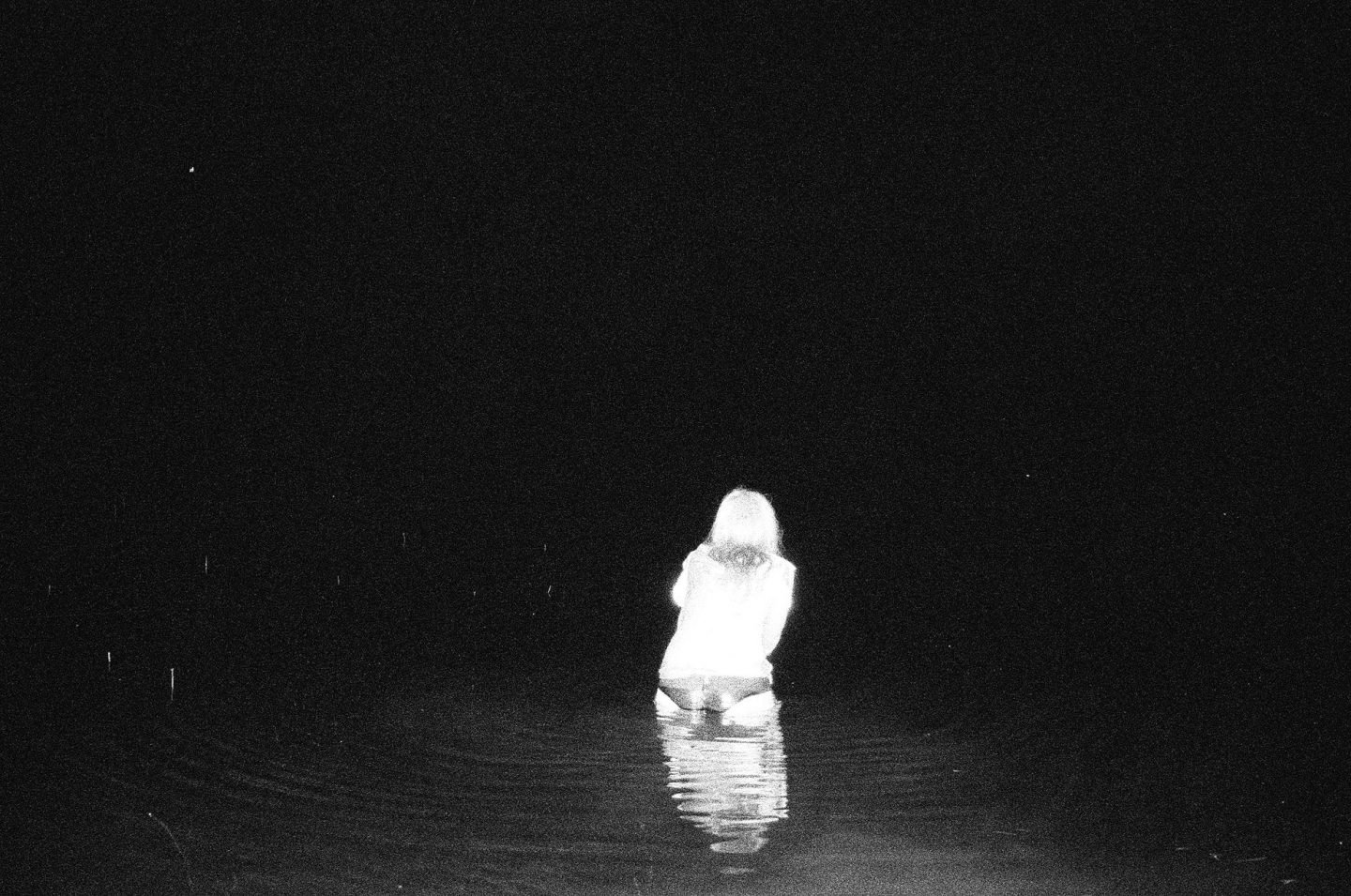 “a black and white photo of a woman standing in the sea from Lina Scheynius